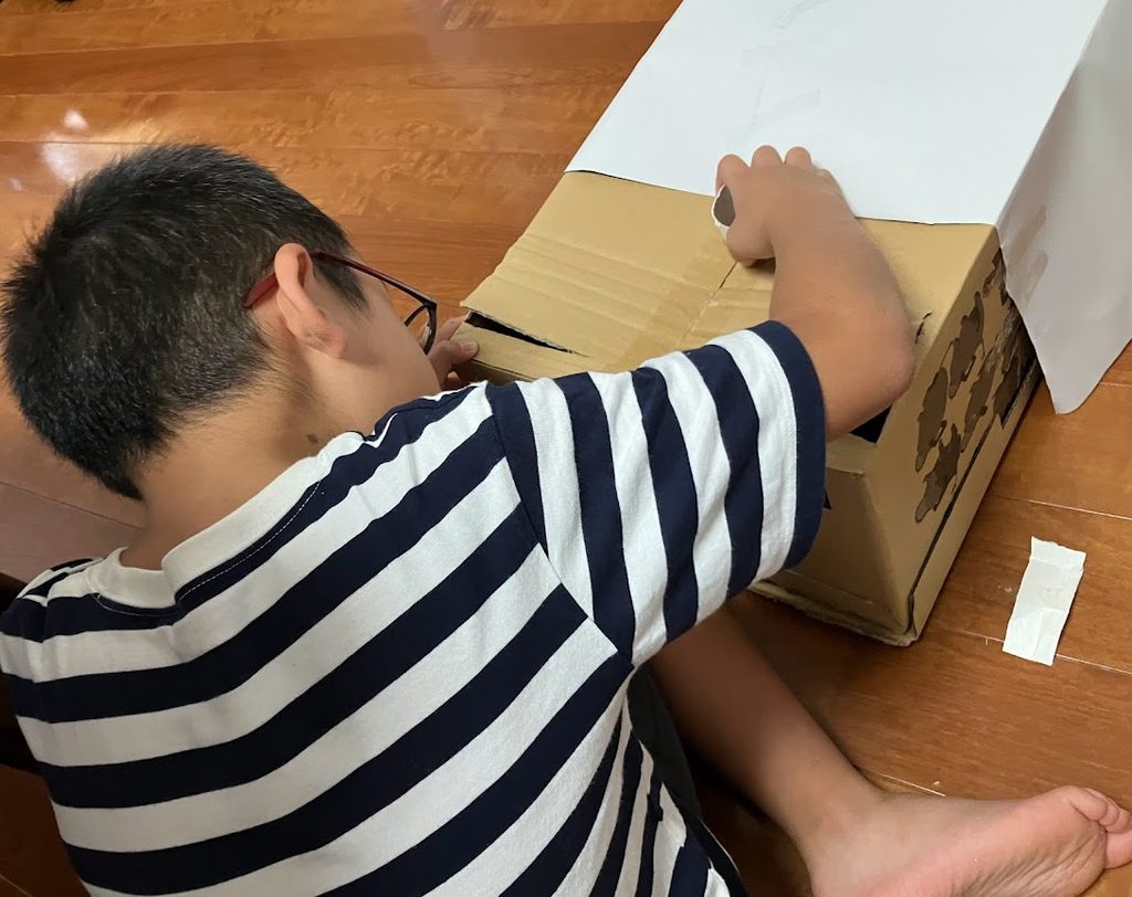 段ボールを使って遊び方を工夫する子ども